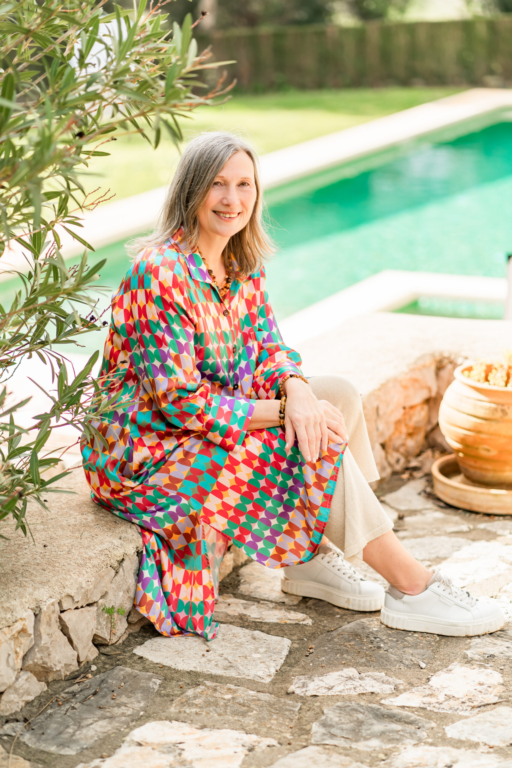 Angela Eggert in buntem Outfit am Pool